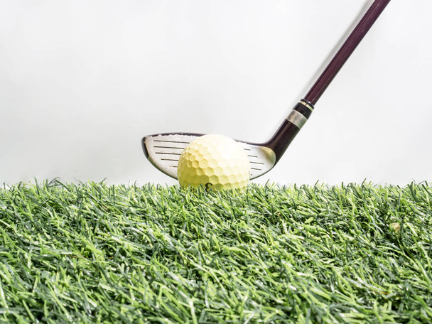 Conducir la pelota de golf con el conductor en césped artificial y fondo blanco
 - Foto, imagen