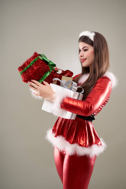 Beautiful young Santa girl with presents to give - Foto, Imagem