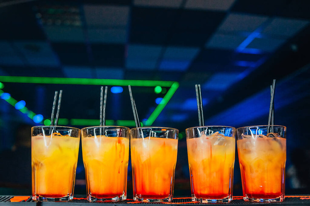glasses with cocktails on blurred nightclub background - 写真・画像