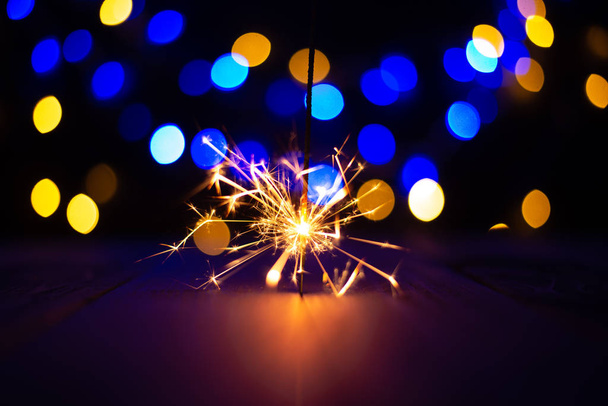 festive christmas background with burning sparkler - 写真・画像
