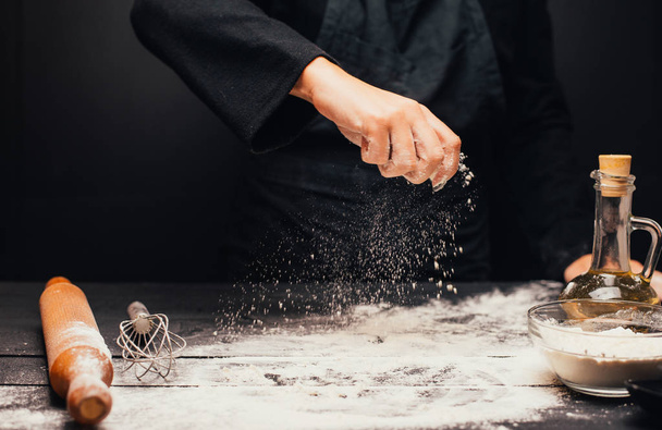 cropped shot of person sifting flour on dark wooden table white cooking dough - Fotografie, Obrázek