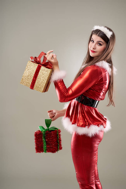 Beautiful young Santa girl with presents to give - Photo, image