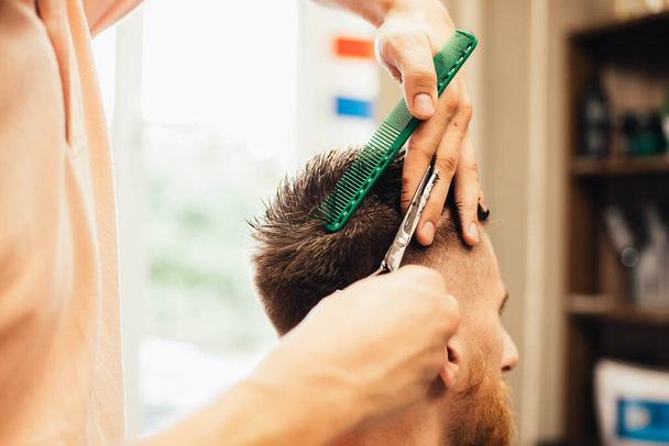 Barbershop. Close-up of man haircut, master doing the hair styling in barber shop - Valokuva, kuva