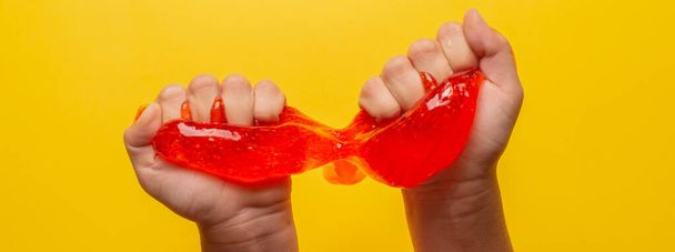 cropped shot of kid playing with handmade toy slime on yellow background - Фото, зображення
