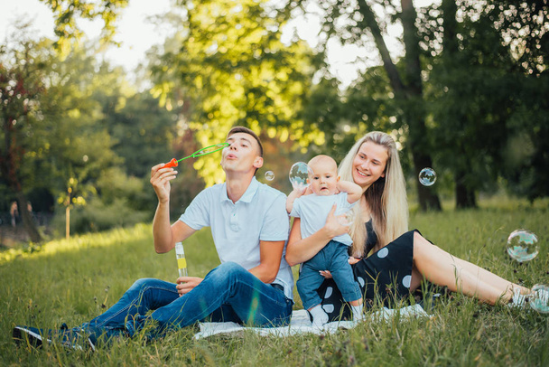  young family with baby son at summer with soap bubbles - Fotoğraf, Görsel