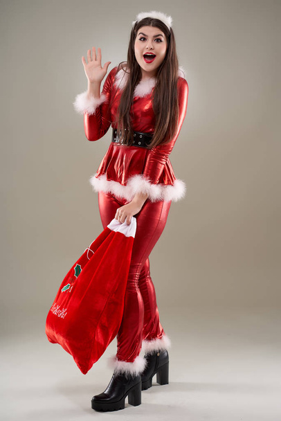 Full length of a Santa girl with a sack full of presents - Фото, зображення