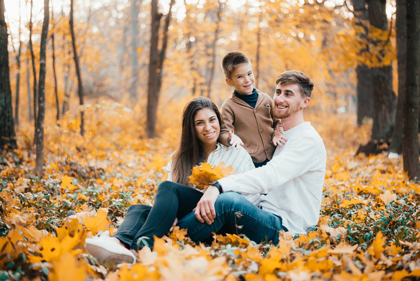 gyönyörű boldog fiatal család egy gyerekkel együtt töltik az időt az őszi parkban - Fotó, kép
