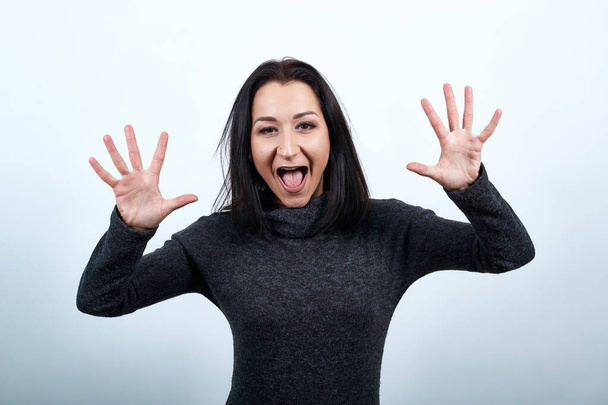Crazy caucasian young woman showing palms at camera, showing tongue - 写真・画像