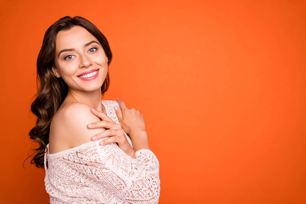 Portrait of charming attractive girl hug herself enjoy luxury party look good wear knitted blouse isolated over orange color background - 写真・画像