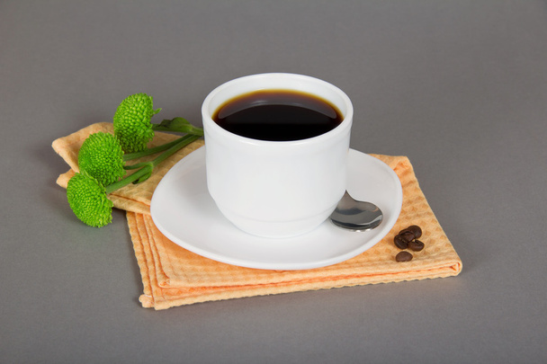 Tasse de café, soucoupe, cuillère, serviette et chrysanthème vert, sur un fond gris
 - Photo, image