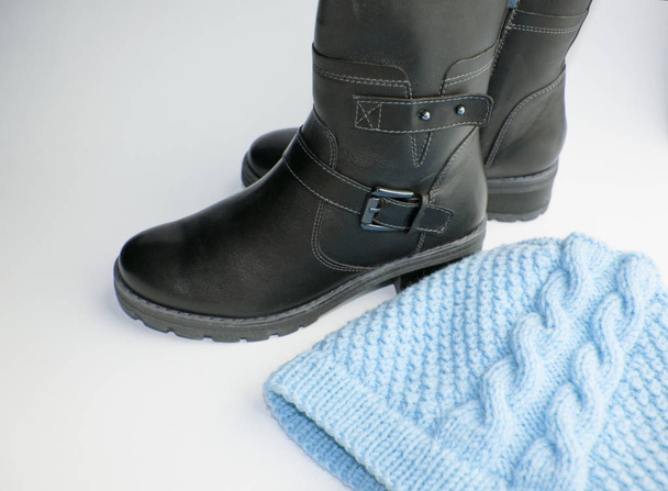 Moda zima buty damskie-czarne buty skórzane i dzianiny kapelusz na białym tle, koncepcja zakupu ciepłych ubrań i butów na zimę - Zdjęcie, obraz