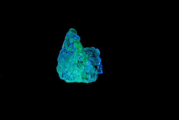 μακροσκοπική ορυκτή πέτρα opal κάτω από υπεριώδες φως σε μαύρο πίσω - Φωτογραφία, εικόνα