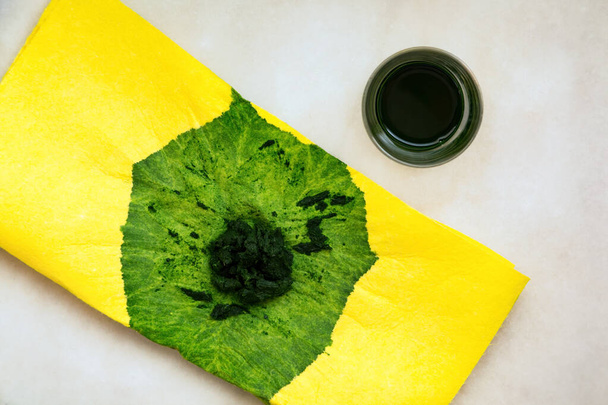 Succo di spinaci spremuto a mano con un panno giallo
 - Foto, immagini