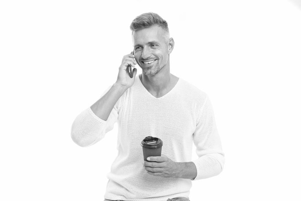 Sharing good news. Mobile communication. Drink it on the go. Coffee take away. Mature man hold paper coffee cup stand white background. Delicious fresh coffee concept. Good mood. Enjoying his coffee - Photo, image