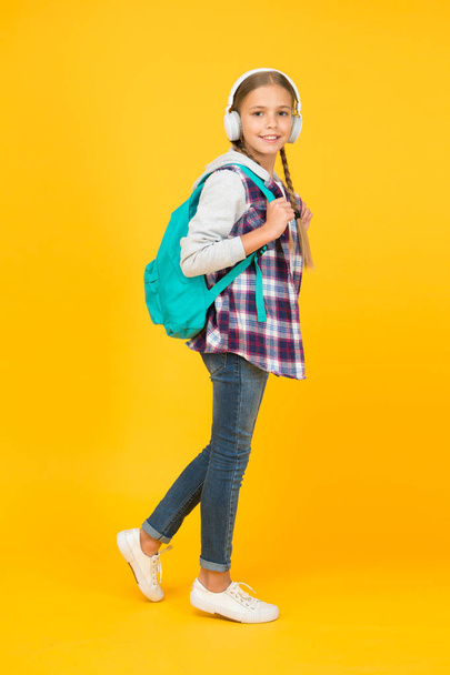 Energetic cheerful teen listening music. Stylish schoolgirl going to school. Girl little fashionable girl with backpack. School life. Happy carefree child. School classes. Student. Modern education - Φωτογραφία, εικόνα