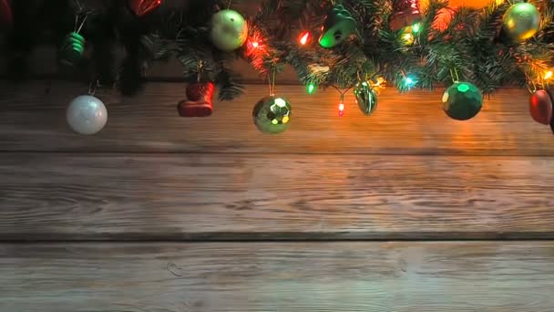 Knipperende kerstboombloemenslinger met chrisymas boomdecoratie op houten plank. Heldere kerst- en nieuwjaarsachtergrond met lege ruimte voor tekst - Video