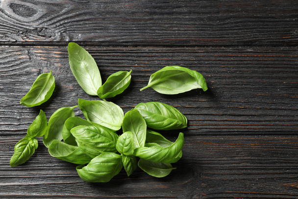 Fresh green basil on black wooden table, top view - Photo, Image