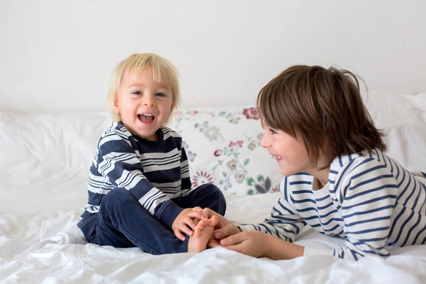 Brothers, playing at home, tickling feet laughing and smiling  - Foto, immagini