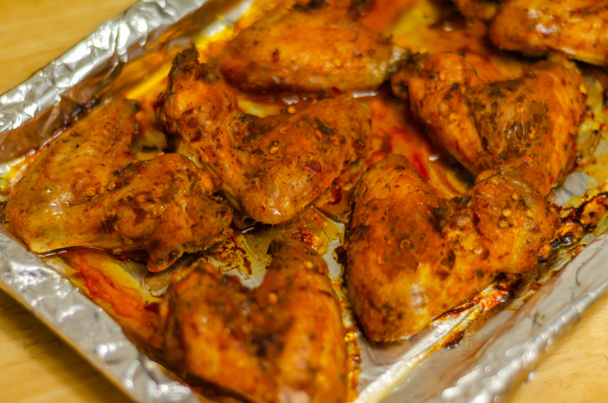 Roasted chicken wings marinated in a spicy peri-peri sauce, a delicious snack - Photo, Image