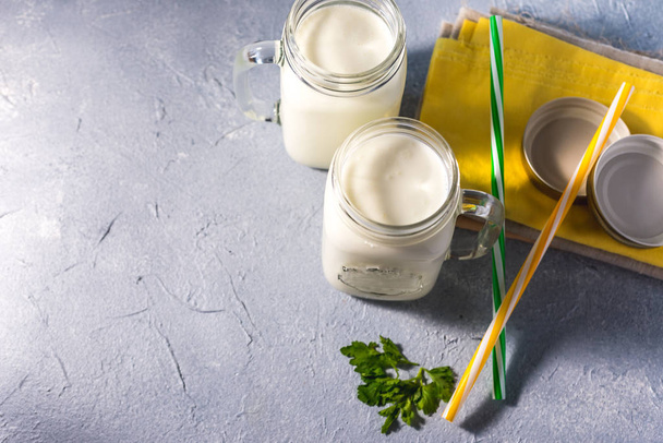 eenvoudige zelfgemaakte kefir in een glas met specerijen en kruiden op een grijze achtergrond, kopieer ruimte. Probioticum Ayran - Foto, afbeelding
