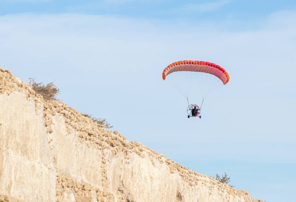 Atletas em um paraquedas motorizado voam sobre as ruínas do aqueduto romano perto da cidade de Cesareia, no norte de Israel
 - Foto, Imagem