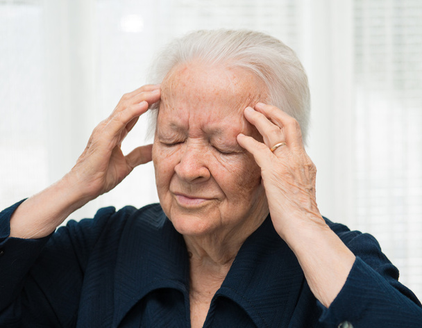 bejaarde vrouw met hoofdpijn - Foto, afbeelding