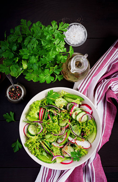 Здоровое веганское питание. Вегетарианский овощной салат из редиса, огурцов, салата и красного лука. Вид сверху, пространство для копирования
 - Фото, изображение