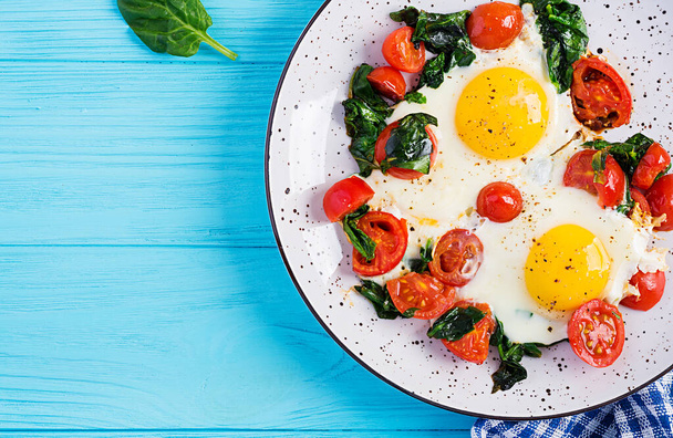 El desayuno. Alimento dietético cetogénico. Huevo frito, espinacas y tomates. Keto, desayuno paleo. Vista superior, espacio de copia
 - Foto, imagen