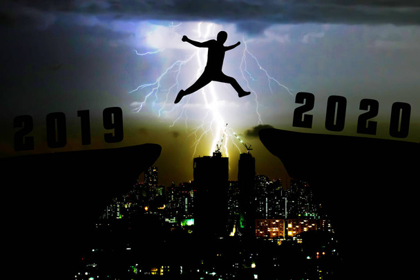Silhouette joven saltando de 2019 a 2020 años
 - Foto, Imagen