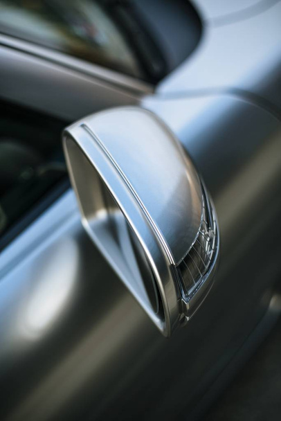 A vertical high angle shot of the side mirror of a beautiful silver car - Foto, afbeelding