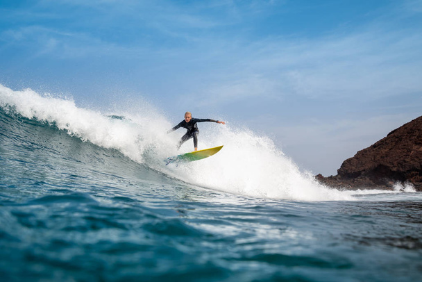 Fuerteventura - September 29, 2019: surfer riding waves on the island of fuerteventura in the Atlantic Ocean - Valokuva, kuva