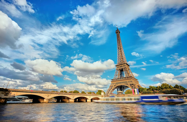 Güneşli bir günde Eyfel kulesiyle Paris 'in şehir manzarası, turistik teknelerin hareketlerini gösteren uzun pozlama - Fotoğraf, Görsel