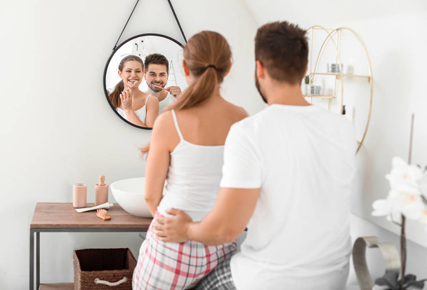 若いカップルの朝バスルームで歯を磨く - 写真・画像