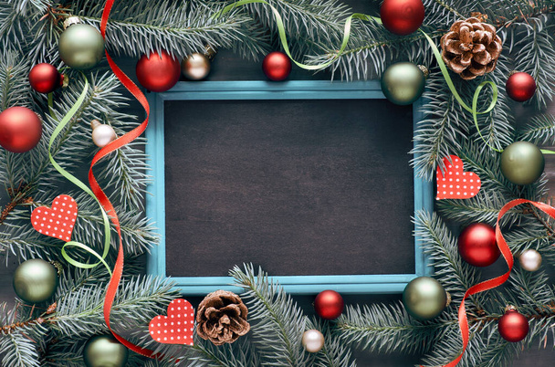 Vánoční rám v zelené a červené, horní pohled s textovým prostorem. Jedlová větvička zdobená cetkami, srdíčky a hvězdami - Fotografie, Obrázek