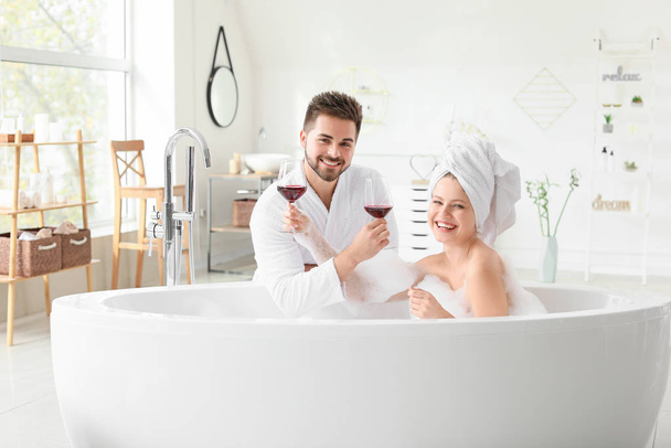 Felice giovane coppia bere vino in bagno
 - Foto, immagini
