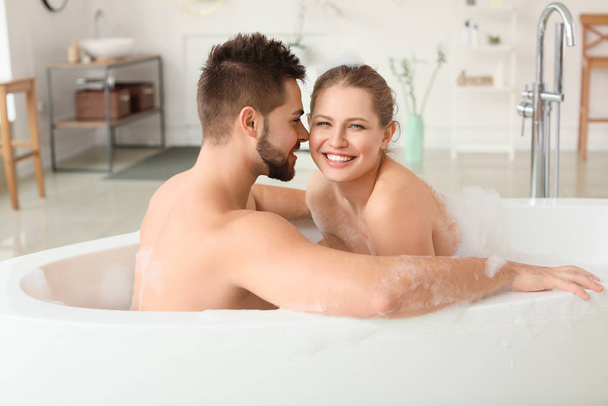 Happy young couple taking bath together - Фото, изображение
