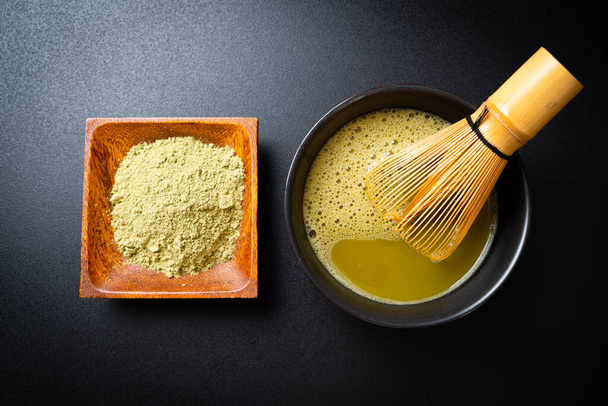 hot matcha green tea cup with green tea powder and whisk - Foto, Imagem