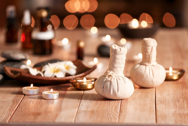 Kräuterbeutel und Kerzen auf dem Tisch im Wellnesssalon - Foto, Bild