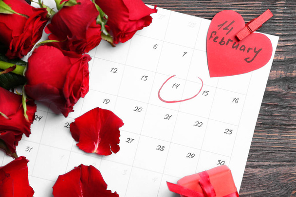 Calendar and rose flowers on wooden background. Valentine's Day celebration - Photo, Image
