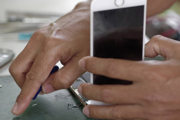 primer plano del hombre reparación de teléfonos inteligentes
   - Foto, Imagen