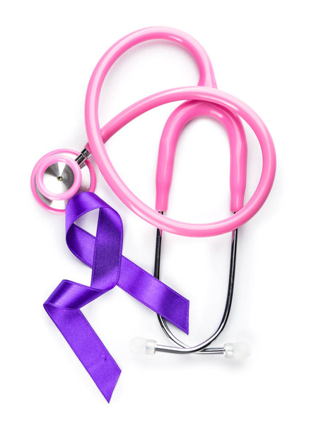 Purple ribbon as symbol of World Cancer Day and stethoscope on white background - Foto, Imagen