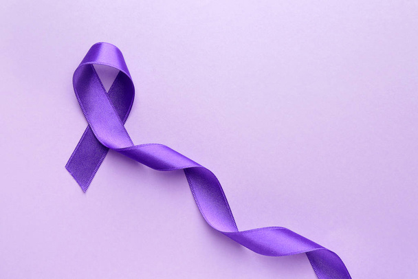 Purple ribbon as symbol of World Cancer Day on color background - Foto, Imagen