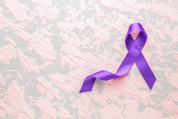 Cinta púrpura como símbolo del Día Mundial del Cáncer sobre fondo de color
 - Foto, Imagen