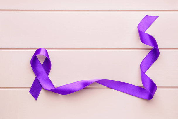 Fioletowa wstążka symbolem Światowego Dnia Raka na drewnianym tle - Zdjęcie, obraz