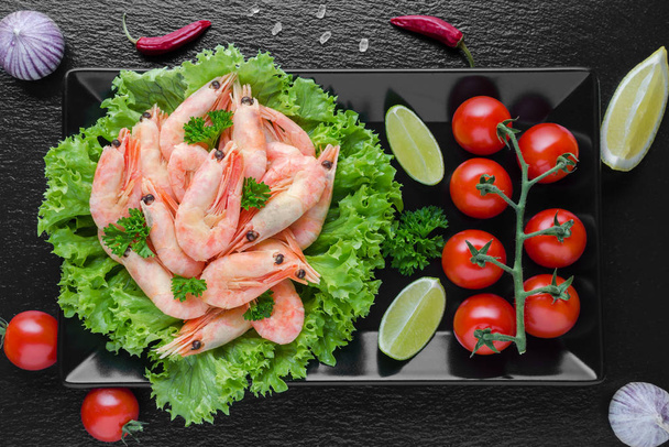 siyah arka plan üzerinde kireç ile domates, biber ve sarımsak ile lezzetli ızgara karides - Fotoğraf, Görsel