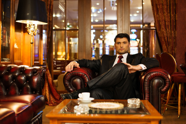 Confident handsome brunette sitting in luxury interior - Photo, Image