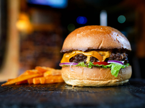 Крупный план вкусного гамбургера и картошки фри, концепция быстрого питания
 - Фото, изображение
