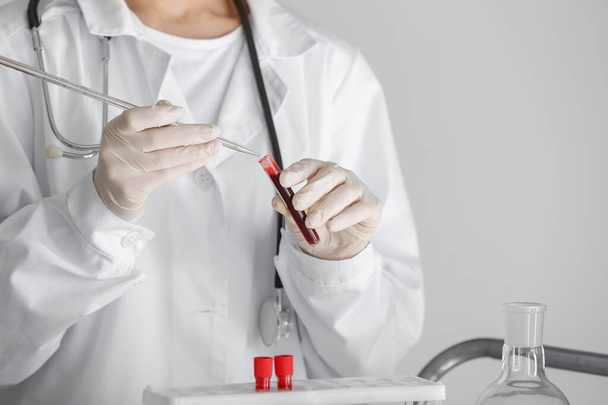 Vrouw die werkt met bloedmonster in laboratorium, close-up - Foto, afbeelding