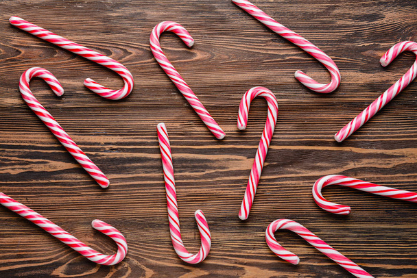 Candy canes on wooden background - Foto, afbeelding