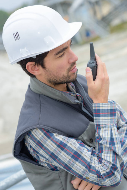 foreman using walkie-talkie on construction site - Foto, immagini